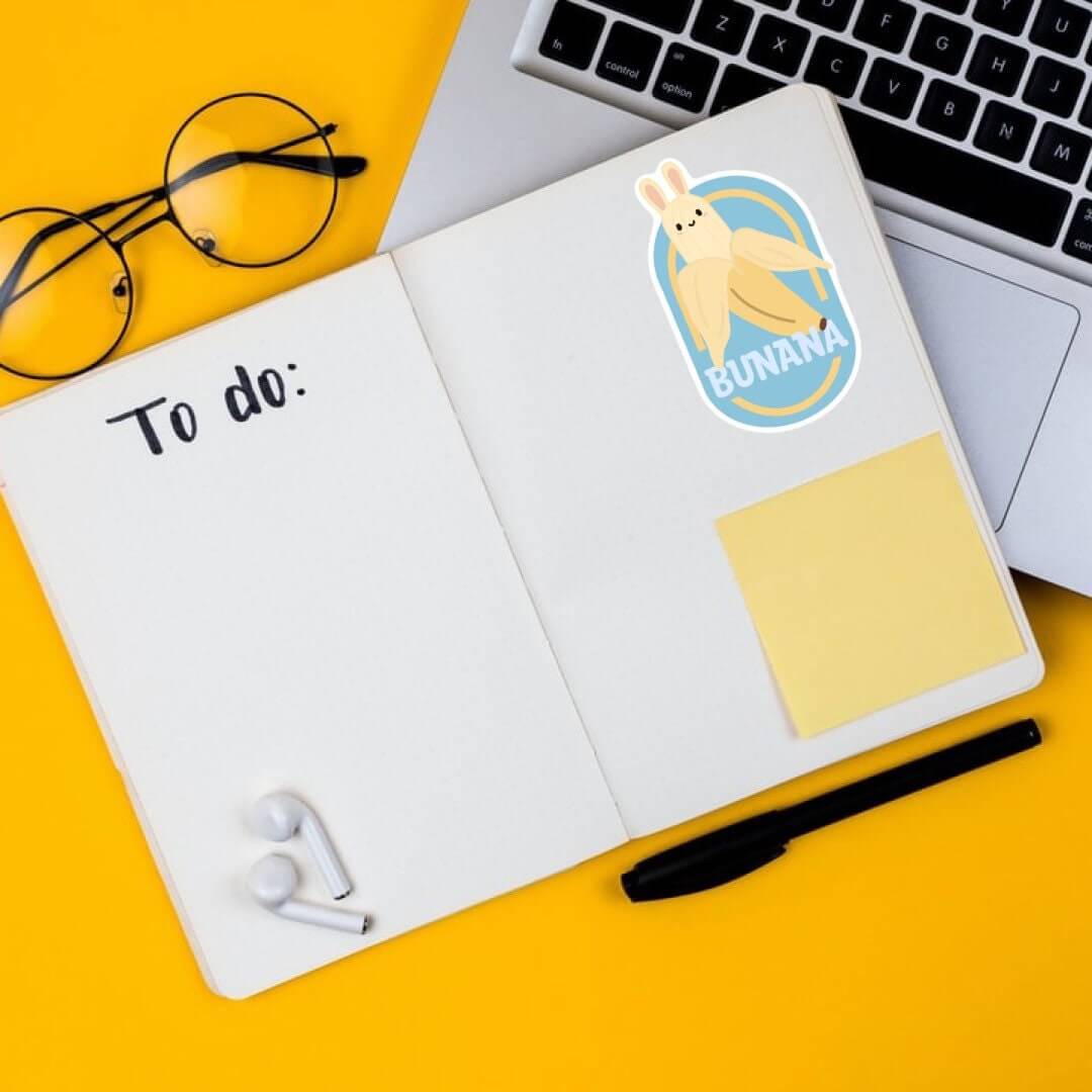 A large bunana sticker shown on a notebook. Stickers are waterproof, weather proof and UV resistant. Can be placed just about anywhere even your water bottle or car!