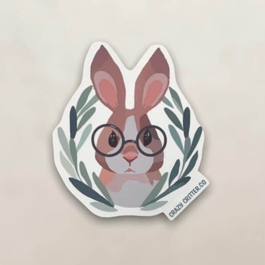 Vinyl sticker of a cartoon style drawing of a brown rabbit with funny glasses surrounded by a green wreath.